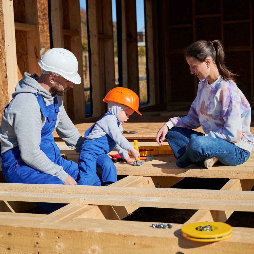 father, mother and son building wooden frame house.